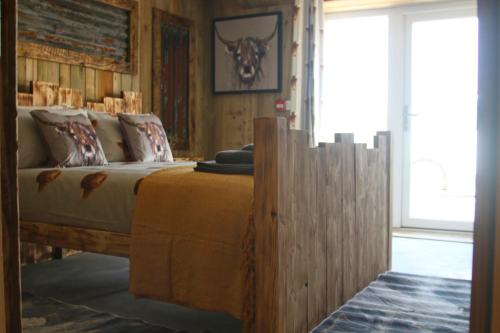 a bedroom with a wooden bed with a hat on it at The Moo-tel at Moody Meadows in Aberaeron