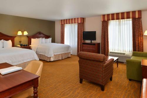 a hotel room with two beds and a chair at Hampton Inn & Suites - Coors Road in Albuquerque