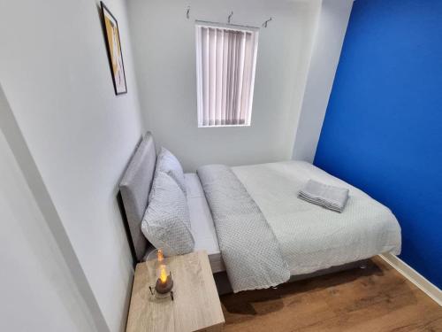 a small room with a bed and a table with a candle at Charming Accommodation Steps from Downtown in Liverpool