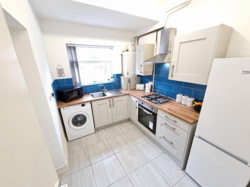 a small kitchen with a sink and a refrigerator at Charming Accommodation Steps from Downtown in Liverpool