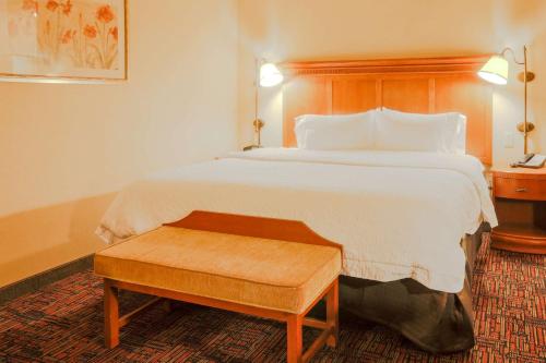 a hotel room with a large bed with a wooden headboard at Hampton Inn & Suites by Hilton Tomball Houston NW in Tomball