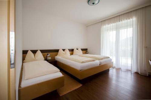 a bedroom with two beds and a window at Familienhotel Steindl in Millstatt