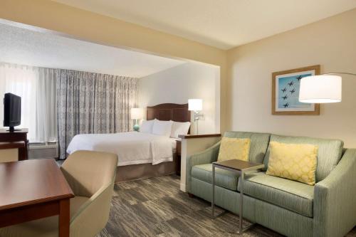 a hotel room with a bed and a couch and a chair at Hampton Inn Fort Worth Southwest Cityview in Fort Worth