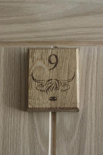 a sign on a wooden table with the number six at The Moo-tel at Moody Meadows in Aberaeron