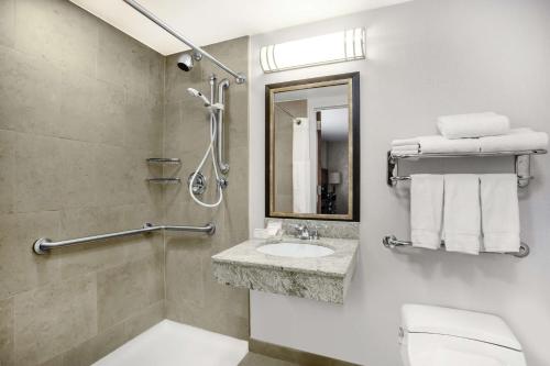 y baño con aseo, lavabo y espejo. en Hilton Garden Inn West 35th Street, en Nueva York