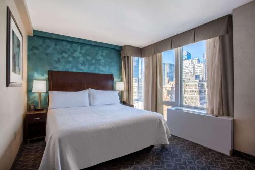 sypialnia z dużym łóżkiem i dużym oknem w obiekcie Hilton Garden Inn West 35th Street w Nowym Jorku
