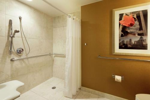a bathroom with a shower and a toilet at DoubleTree by Hilton Hotel Dallas Campbell Centre in Dallas