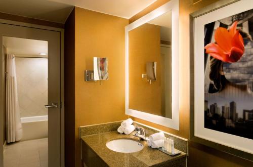 a bathroom with a sink and a mirror at DoubleTree by Hilton Hotel Dallas Campbell Centre in Dallas