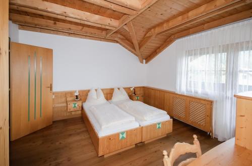 a bedroom with a bed and a wooden ceiling at Familienhotel Steindl in Millstatt