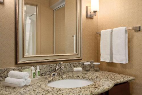 a bathroom with a sink and a mirror and towels at Homewood Suites Atlantic City Egg Harbor Township in Egg Harbor Township