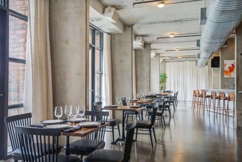 a row of tables and chairs in a room with windows at NYLO Dallas Plano Hotel, Tapestry Collection by Hilton in Plano