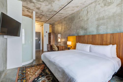 una camera con un grande letto e una TV di NYLO Dallas Plano Hotel, Tapestry Collection by Hilton a Plano