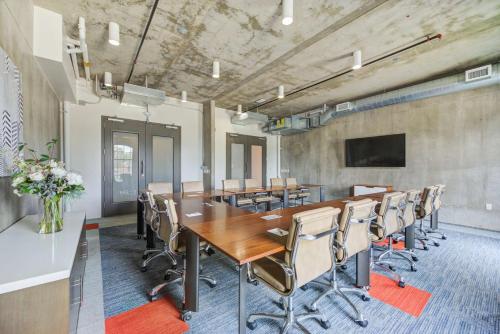 an office with a conference room with a long table and chairs at NYLO Dallas Plano Hotel, Tapestry Collection by Hilton in Plano
