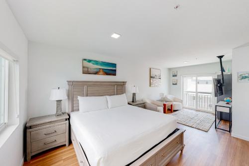 a bedroom with a large white bed and a desk at Mermaid's Retreat in Marathon