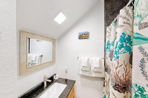 a bathroom with a sink and a mirror at Mermaid's Retreat in Marathon