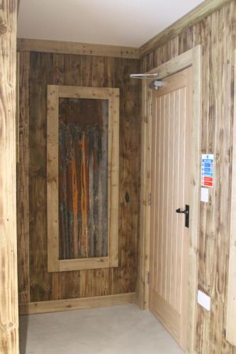 a room with wooden walls and a door at The Moo-tel at Moody Meadows in Aberaeron