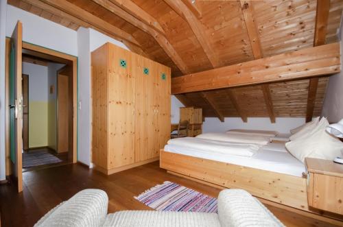 a bedroom with a bed and two chairs at Familienhotel Steindl in Millstatt