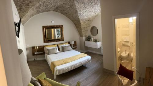 a bedroom with a bed and a bathroom with a mirror at La Fabbrica di San Pietro Vasto in Vasto