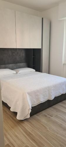 - une chambre avec un grand lit et des draps blancs dans l'établissement LOANO PERLA LIGURE, à Loano