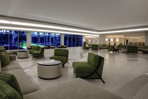 a lobby with green chairs and tables in a building at DoubleTree by Hilton at the Entrance to Universal Orlando in Orlando
