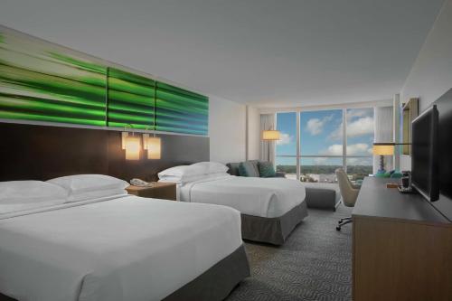a hotel room with two beds and a flat screen tv at DoubleTree by Hilton at the Entrance to Universal Orlando in Orlando