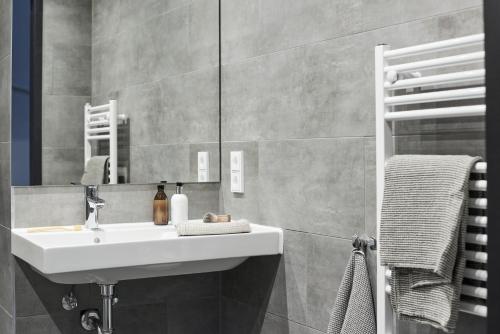 ein Bad mit einem Waschbecken und einem Spiegel in der Unterkunft Nena Apartments Bochum City in Bochum