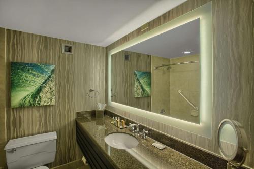 a bathroom with a sink and a toilet and a mirror at DoubleTree by Hilton at the Entrance to Universal Orlando in Orlando