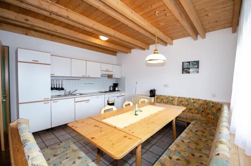 a kitchen and dining room with a wooden table at Familienhotel Steindl in Millstatt