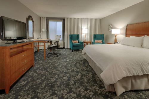 TwinsburgにあるHilton Garden Inn Cleveland/Twinsburgのベッド1台、薄型テレビが備わるホテルルームです。