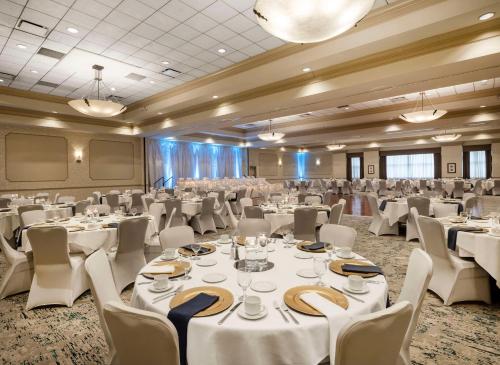 a banquet room with white tables and white chairs at Hilton Garden Inn Cleveland/Twinsburg in Twinsburg