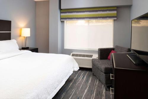 a hotel room with a bed and a chair and a window at Hampton Inn Glenwood Springs in Glenwood Springs