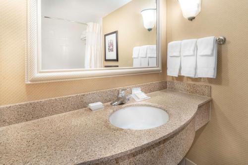a bathroom with a sink and a mirror at Hilton Garden Inn Houston/The Woodlands in The Woodlands