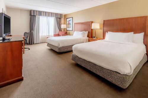 a hotel room with two beds and a flat screen tv at Hilton Garden Inn Houston/The Woodlands in The Woodlands