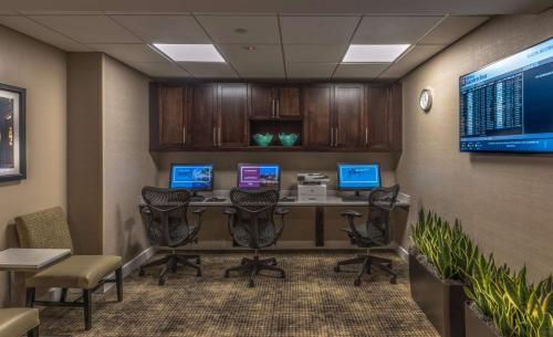 an office cubicle with a desk with computers and chairs at Hilton Garden Inn Reagan National Airport in Arlington