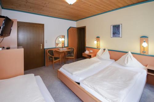 a hotel room with two beds and a desk at Familienhotel Steindl in Millstatt