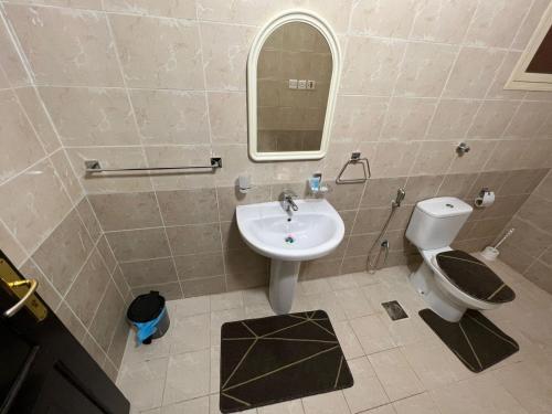 W łazience znajduje się umywalka, toaleta i lustro. w obiekcie شقق الفتح الخاصة Al-Fateh Private Apartments w Medynie