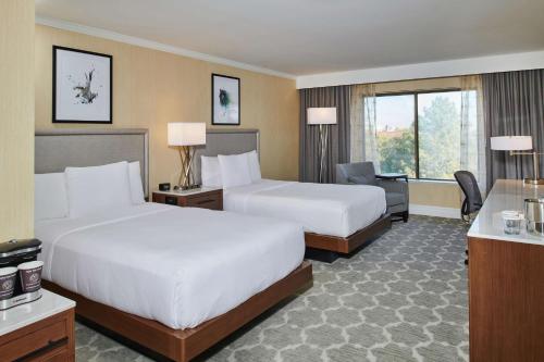 a hotel room with two beds and a desk at DoubleTree by Hilton Hotel Salt Lake City Airport in Salt Lake City
