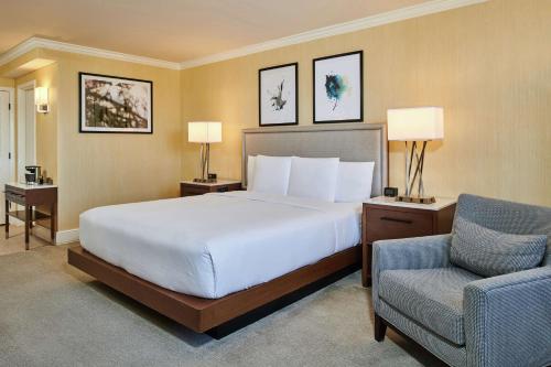 um quarto de hotel com uma cama e uma cadeira em DoubleTree by Hilton Hotel Salt Lake City Airport em Salt Lake City