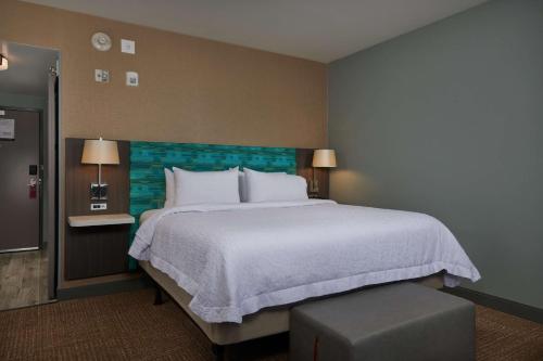 a bedroom with a large bed with a blue headboard at Hampton Inn Sherwood Portland in Sherwood