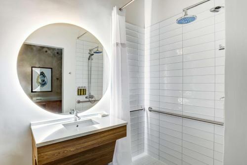 uma casa de banho com um lavatório e um espelho em NYLO Providence Warwick Hotel, Tapestry Collection by Hilton em Warwick