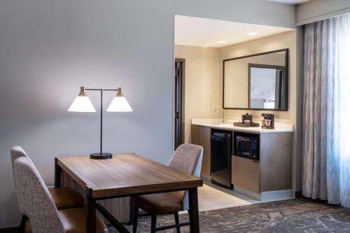 Embassy Suites by Hilton Albuquerque في ألباكيركي: مطبخ وغرفة طعام مع طاولة وكراسي