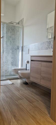 La salle de bains est pourvue d'une baignoire et d'une douche en verre. dans l'établissement LOANO PERLA LIGURE, à Loano