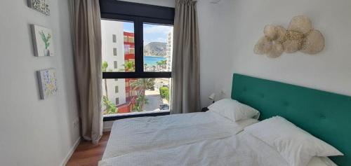 ein Schlafzimmer mit einem Bett und einem großen Fenster in der Unterkunft Apartamento Elegance en Calpe in Calpe