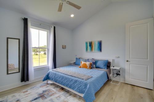 a bedroom with a bed with blue sheets and a window at Sunny Gulfport Vacation Rental Walk to Beaches! in Gulfport