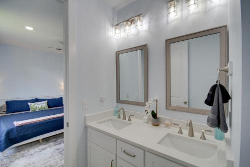 a bathroom with a sink and a mirror and a bed at Sunny Gulfport Vacation Rental Walk to Beaches! in Gulfport