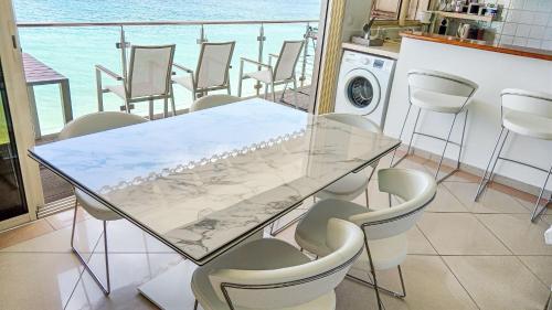 a dining room with a glass table and chairs at Residence Catalina APT 3 in Grand Case