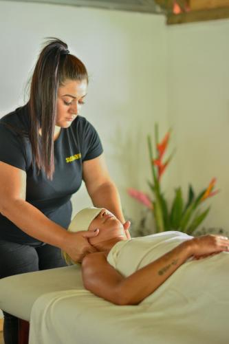 a woman is getting a massage from a woman on a bed at Hotel Luna Llena in Tamarindo