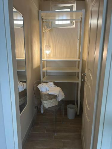 a small bathroom with a closet with towels and a chair at La Fabbrica di San Pietro Vasto in Vasto