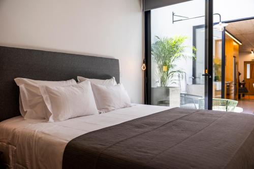 a bedroom with a large bed with white pillows at Casa Da Avo Clementina Nº32 in Funchal