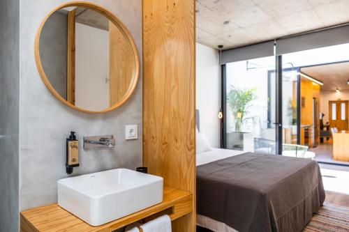 a bathroom with a sink and a bed and a mirror at Casa Da Avo Clementina Nº32 in Funchal